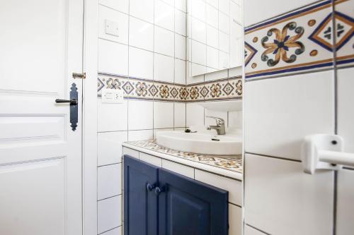 baño con lavabo y puerta azul en Casa Bernia Vista, en Benitachell