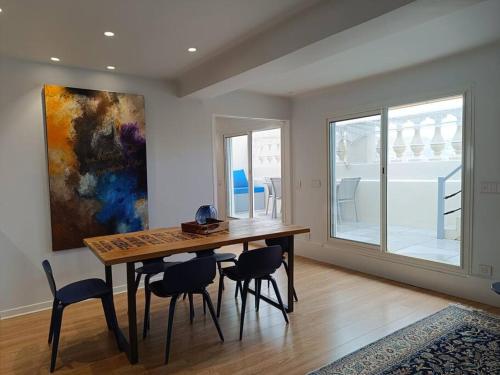 une salle à manger avec une table et des chaises et un tableau dans l'établissement See front Premium Location - Panoramic view -, à Cannes