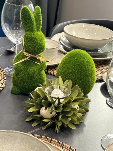 a table with a green bunny and a plant on it at DOMKI BURSZTYN in Mrzeżyno