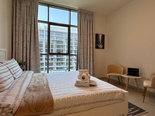um quarto com uma cama e uma grande janela em CityVibesDxb em Dubai