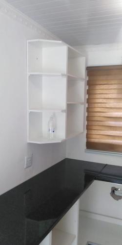 een keuken met witte kasten en een zwart aanrechtblad bij 17 on Driffield in East London