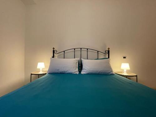 a green bed with two lamps on two tables at Yas Marina (Maison Porto Canale) in Cesenatico