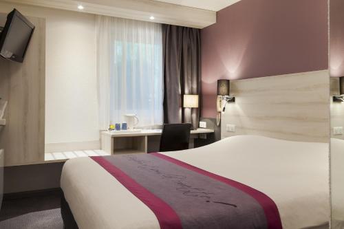 a hotel room with a bed and a desk at Kyriad Lille Est - Villeneuve d'Ascq in Villeneuve d'Ascq