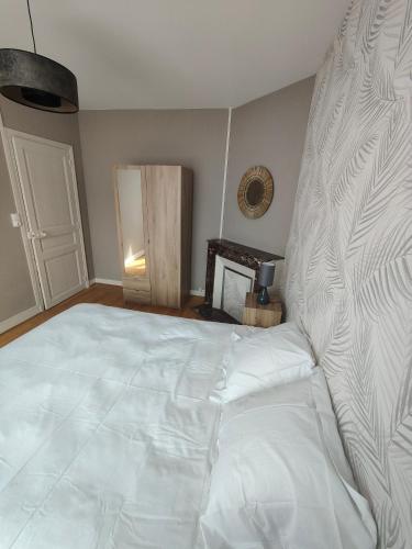 une chambre avec un grand lit blanc dans une pièce dans l'établissement Appartement cosy rethel, à Rethel