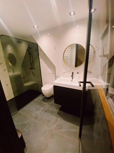 a bathroom with a sink and a toilet and a mirror at LONG BEACH ROOMS 3 in Zandvoort