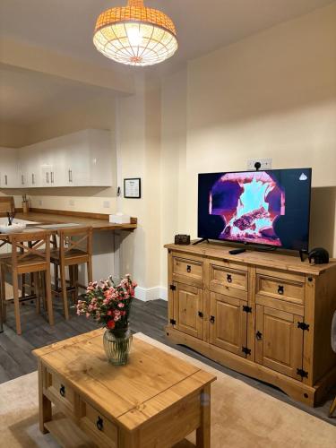 a living room with a flat screen tv on a large entertainment center at Cardiff/Pernath Home2 in Cardiff