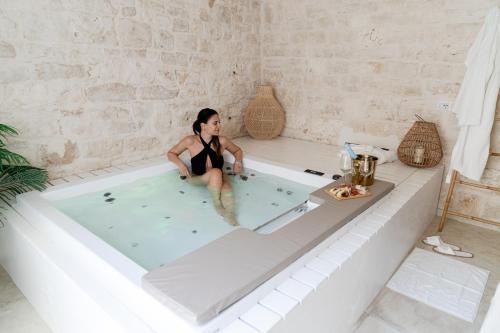una mujer sentada en una bañera en Aurluna Luxury Suites, en Bari