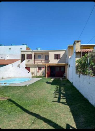 a yard with a house and a swimming pool at Casa com piscina in Rio Grande