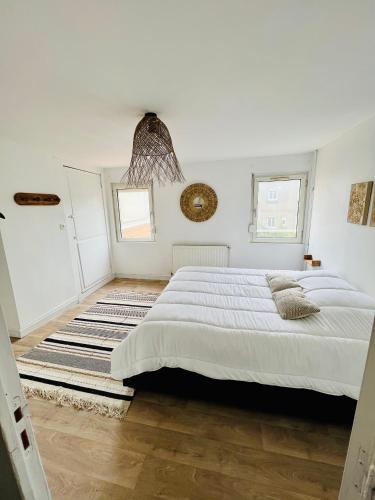 - une chambre blanche avec un grand lit et un tapis dans l'établissement Les Sables de Berck, à Berck-sur-Mer