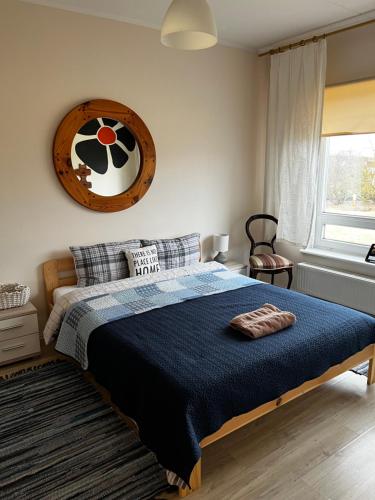 sypialnia z łóżkiem i zegarem na ścianie w obiekcie Cosy house in Center of Tartu w mieście Tartu