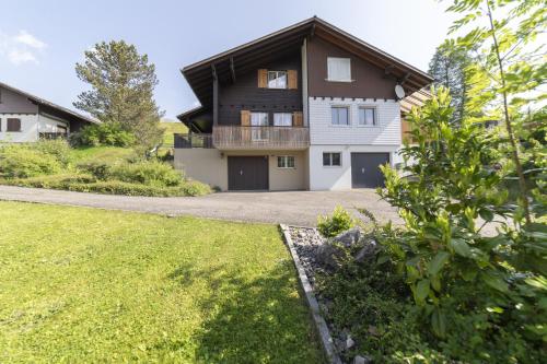 a house with a driveway and a grass yard at Schönau in Wildhaus