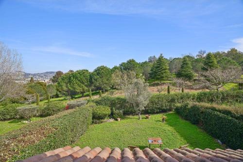 Elle offre une vue sur un jardin avec des buissons et des arbres. dans l'établissement House with garden and swimming pool shared, à Cannes