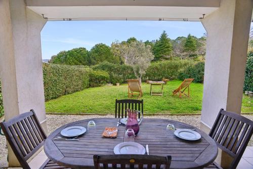 - une table en bois avec des chaises sur une terrasse avec vue dans l'établissement House with garden and swimming pool shared, à Cannes