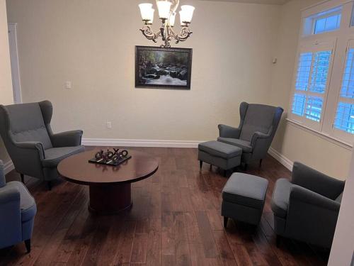 a waiting room with a table and chairs and a chandelier at Majestic newly renovated home surrounded by greenery in Grants Pass