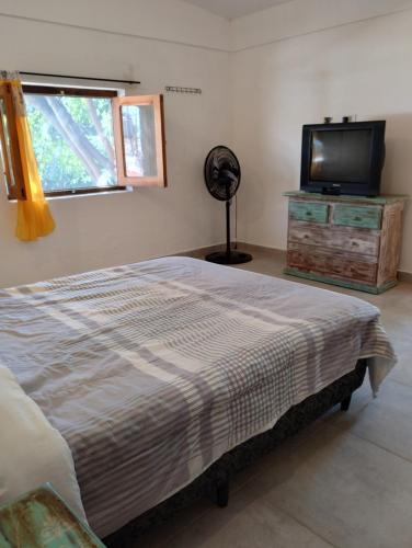 a bedroom with a bed and a flat screen tv at Casa Nuestra Hostal in Salta