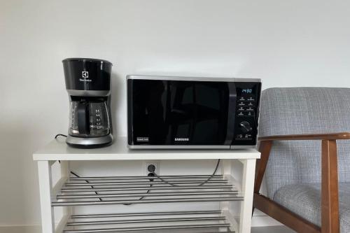 a microwave sitting on a table next to a coffee maker at Trevlig boende i en gästhuset med gratis parkering in Malmö