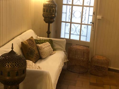 - un salon doté d'un canapé avec des oreillers et d'une fenêtre dans l'établissement Le Rocher, à Sarlat-la-Canéda