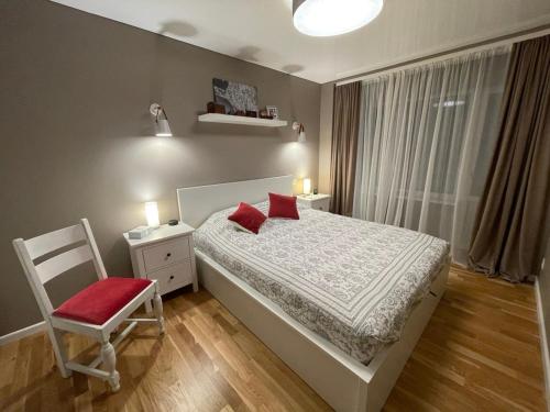 1 dormitorio con 1 cama, 1 silla y 1 ventana en Piektais stāvs / 5th floor, en Ludza