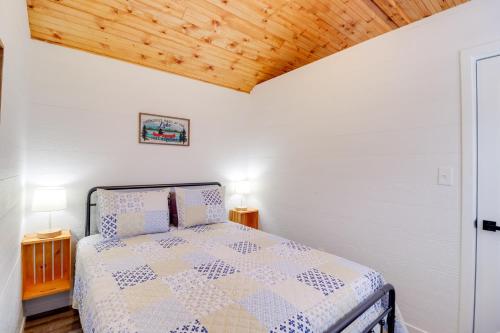 a bedroom with a bed and a wooden ceiling at Steps to Greers Ferry Lake Tumbling Shoals Cabin! in Heber Springs