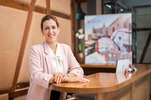 a woman sitting at a table with a laptop at Hotel Boutique ADOLFO in Toledo