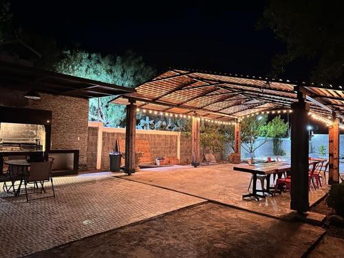 a patio with a wooden pergola at night at La huasteca camping con alberca in Monterrey