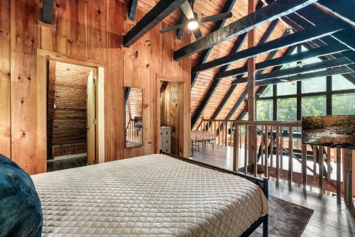 a bedroom with a bed in a room with wooden walls at NEW! Black Bear Chalet Getaway with Games, Hot Tub, RnR, Fun in Sevierville
