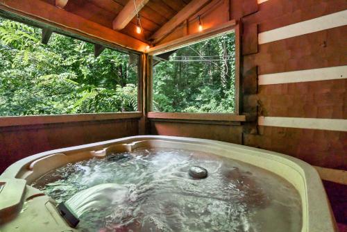 uma banheira num quarto com uma janela em NEW! Black Bear Chalet Getaway with Games, Hot Tub, RnR, Fun em Sevierville