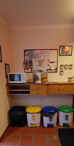 a kitchen with three trash cans and a microwave at Alojamentos Vitinho - Vila Nova Milfontes in Vila Nova de Milfontes