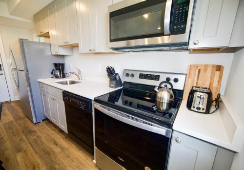 a kitchen with a stove and a microwave at The Chey:Modern and Intimate in Washington, D.C.