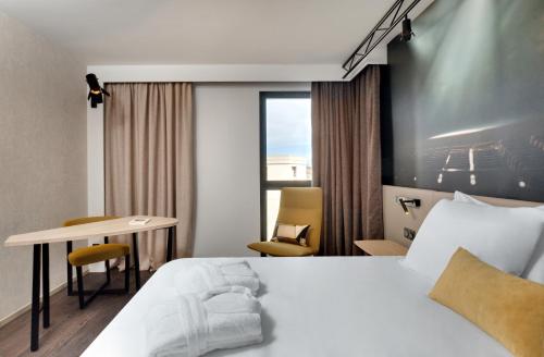 a hotel room with a bed and a desk at Mercure Montpellier Centre Comédie in Montpellier