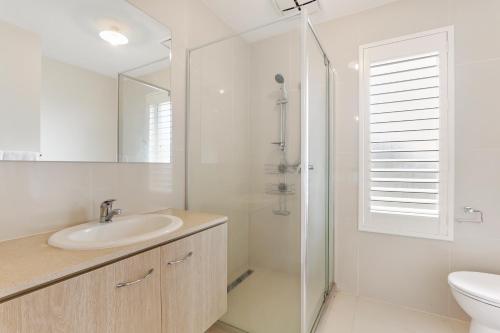 a white bathroom with a sink and a shower at Timeless Safaris in Devon Meadows