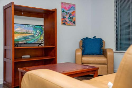 a living room with a couch and a chair and a television at Family condo near Lettuce Lake in Tampa