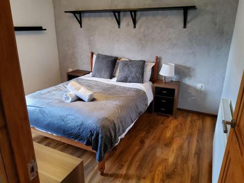 a bedroom with a bed and a wooden floor at Primrose lodge cosy 2 bedroom house in a quiet in Norwich