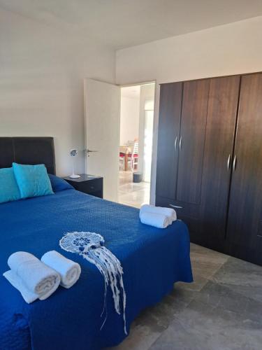 een slaapkamer met een blauw bed en handdoeken bij Departamento en dorrego grande in Guaymallen