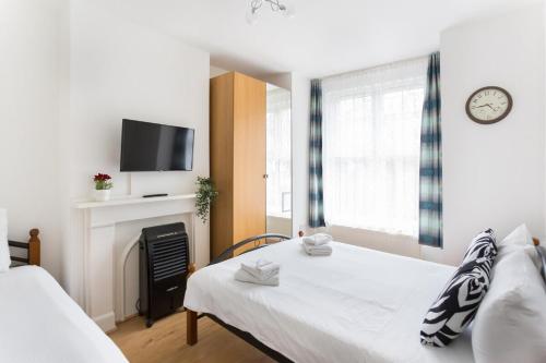 um quarto com uma cama, uma lareira e uma televisão em City Center Camden Market Budget Apartment and Rooms em Londres