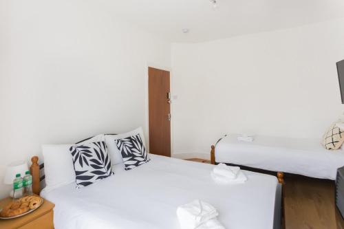 Duas camas num quarto com paredes brancas em City Center Camden Market Budget Apartment and Rooms em Londres