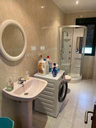 a bathroom with a sink and a washing machine at A CASA DE SISAN in Ribadumia