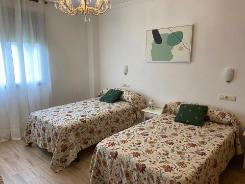 ein Hotelzimmer mit 2 Betten und einem Kronleuchter in der Unterkunft A CASA DE SISAN in Ribadumia