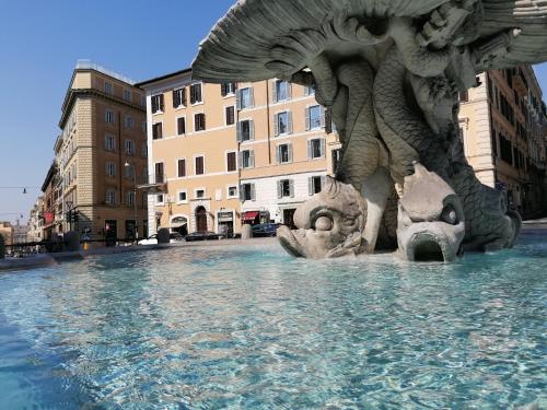 a statue in the middle of a pool of water at Bernini apartment in Rome
