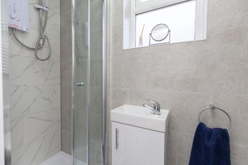 uma casa de banho com um chuveiro, um lavatório e um espelho. em 20 Leys Road rooms 1 - 4 em Wellingborough