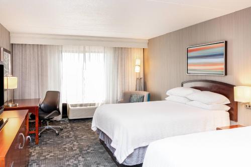 a hotel room with two beds and a desk at Courtyard by Marriott Bloomington in Bloomington