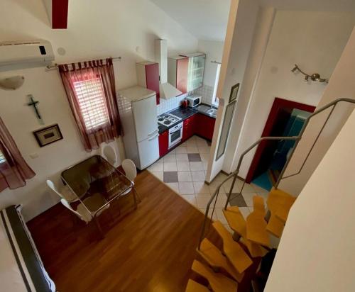 - une vue sur la cuisine dotée de placards rouges dans l'établissement Apartment Beach View, à Kruševo