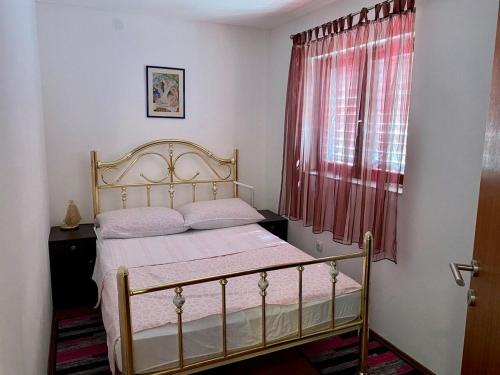 a bedroom with a bed and a window with red curtains at Apartment Beach View in Kruševo