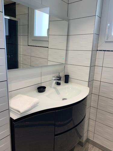 Baño blanco con lavabo y espejo en Appartement T3 - 70m² - L'Espérance, en La Seyne-sur-Mer