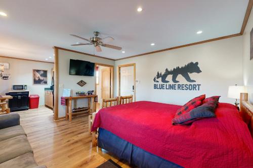 a bedroom with a red bed and a living room at Blue Line Resort Cabin #1 in Carbondale