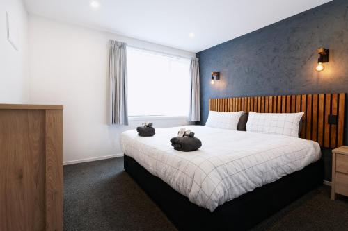 sypialnia z dużym łóżkiem z dwoma pluszakami w obiekcie Hidden Gem in Calton Hill w mieście Dunedin