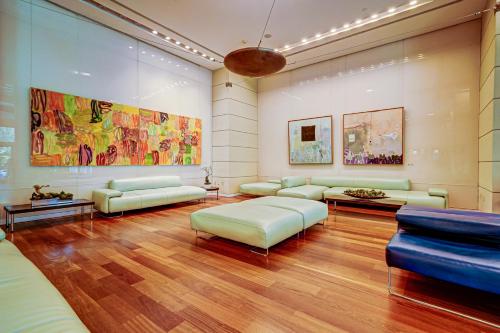 un ampio soggiorno con divani e un dipinto di Direct Bayview One Bedroom Condo in Coconut Grove Includes parking a Miami