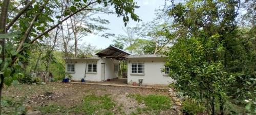 ein kleines weißes Haus mitten im Wald in der Unterkunft CASA RIO in Escuintla