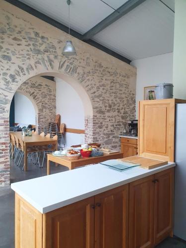 une cuisine avec un comptoir et une salle à manger avec une table dans l'établissement Gîte Les Arches, à Saint-Andéol-le-Château