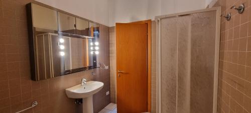 a bathroom with a sink and a mirror and a shower at Via Creti & Via Mazza Rooms in Bologna